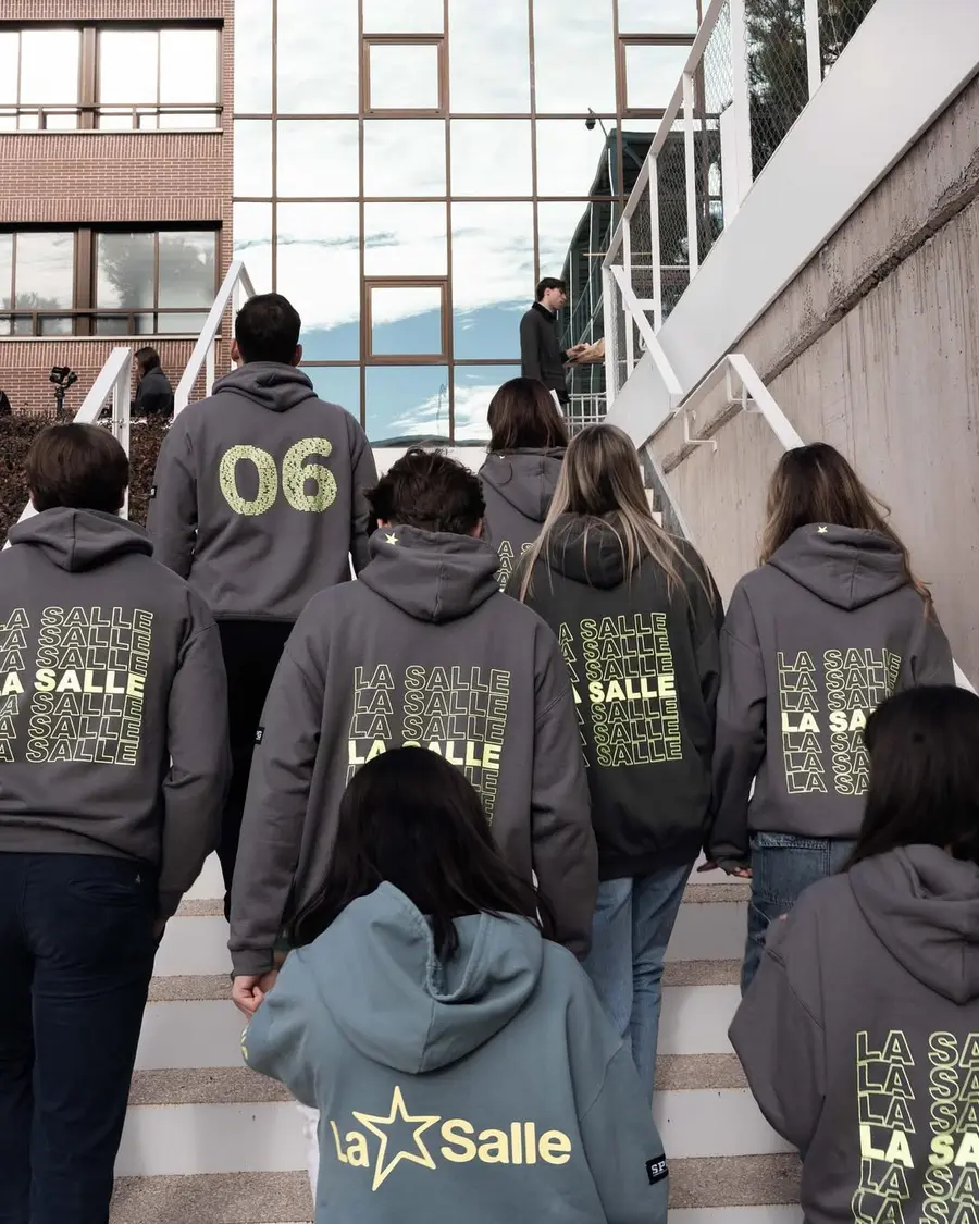 Estudiantes entrando al instituto con sudaderas de grupo personalizadas